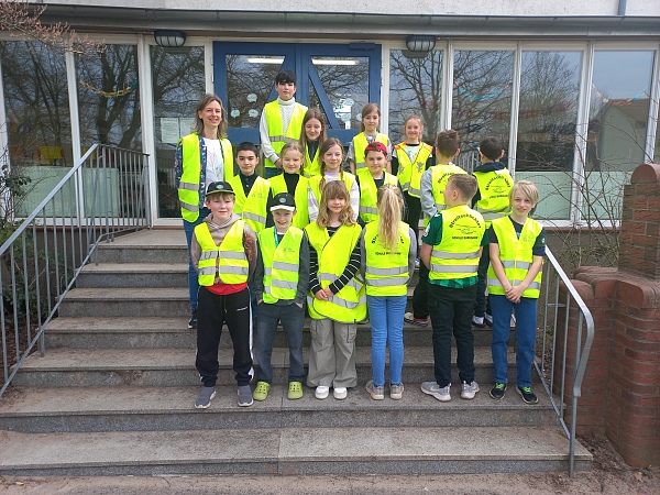 Bild von Kindern in gelben Warnwesten mit einer Lehrerin
